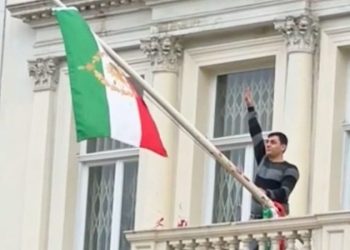 Protester scales Iranian Embassy in London, tears down regime flag, hoists pre-revolution symbol